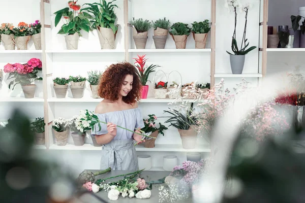 Dolu odada profesyonel çiçekçi olarak çalışan Kıvırcık kadın Işınlama