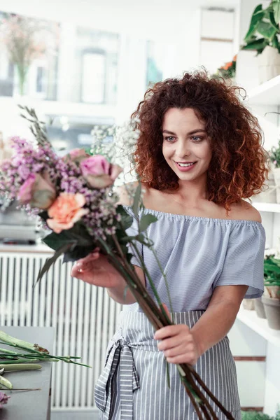 Alegre chica de pelo corto rizado corregir ikebana en sus manos — Foto de Stock