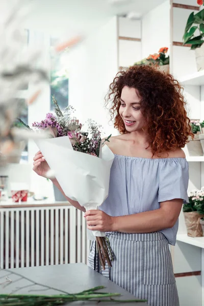 Florista pelirroja radiante asombrada con sus flores compuestas — Foto de Stock