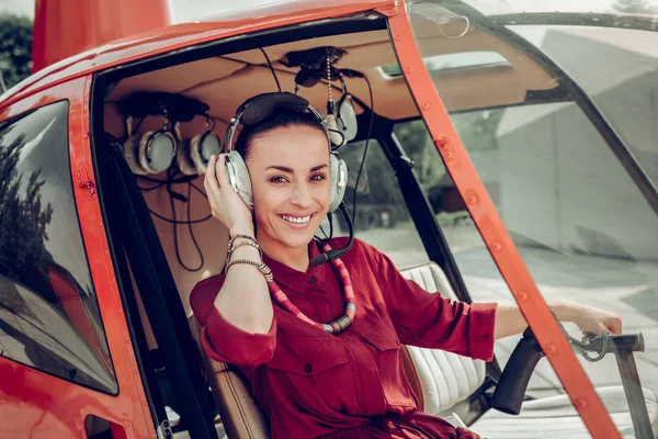 Mulher alegre sentindo-se animado antes de pilotar o helicóptero — Fotografia de Stock