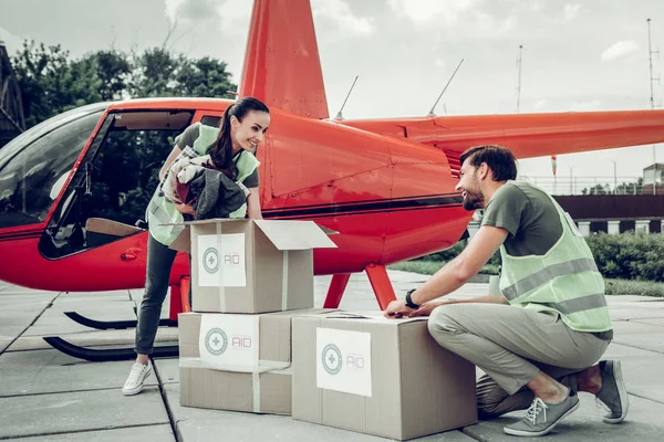 Volunteers packing clothes into boxes for sending them with helicopter