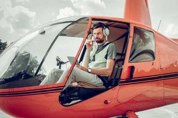 Piloto barbudo con auriculares hablando con su colega — Foto de Stock
