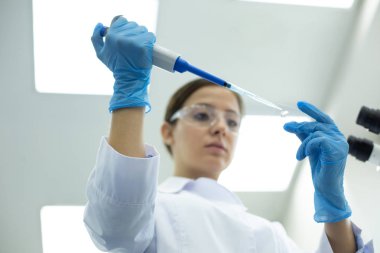 Laboratuvarda kimyasal deney yapan özenli genç araştırmacı