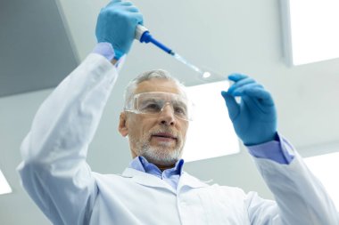 Modern laboratuvarda çalışan özenli olgun araştırmacı