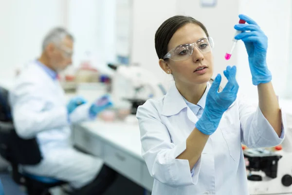 Ernsthafter junger Wissenschaftler macht chemische Experimente im Labor — Stockfoto