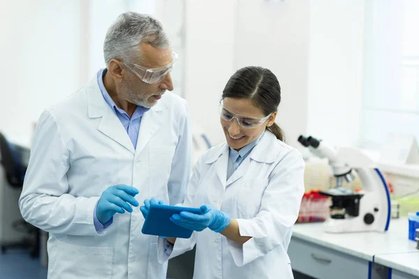 Persona femenina encantada positiva que usa tableta durante el trabajo — Foto de Stock