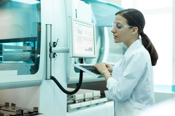 Cheerful young woman looking at working scanner — Stock Photo, Image