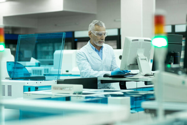 Concentrated senior researcher examining monitor of computer