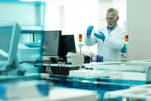 Pessoa masculina sénior concentrada que trabalha em laboratório — Fotografia de Stock