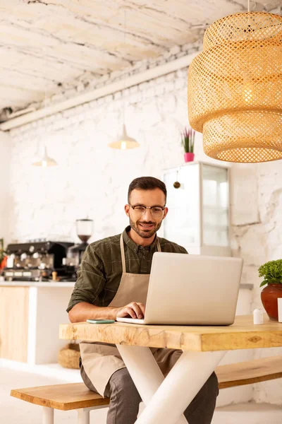 Підприємець сидить у своєму кафе і працює на ноутбуці — стокове фото