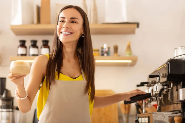 Businesswoman smiling after making coffee in her own cafeteria