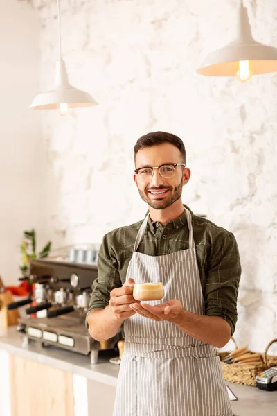 Entrepreneur owning coffee shop holding cup of cappuccino