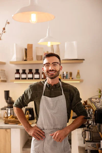 Entrepreneur owning coffee shop standing near coffee machine
