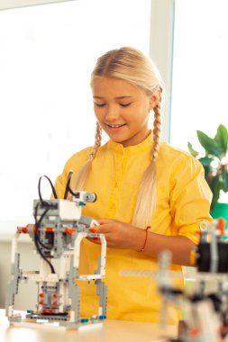 Gülümseyen kız öğrenci onun bilim projesi üzerinde çalışıyor.