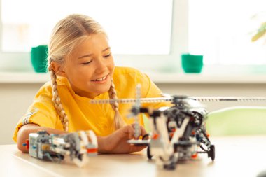 Helikopter modeli yakından bakan ilgilenen kız öğrenci.