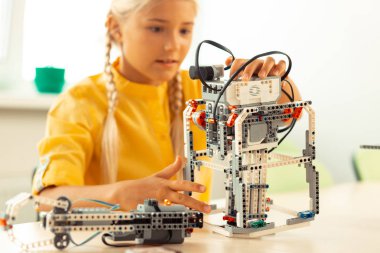 Onun bilim dersi sırasında bir robot bina hevesli kız.