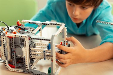 Onun karmaşık robot üzerinde çalışan ciddi bir öğrenci.