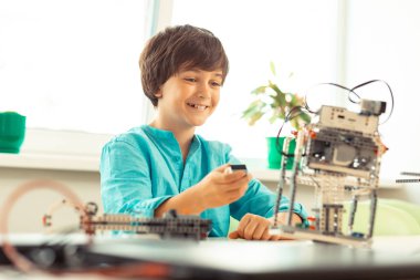 Neşeli çocuk robot modelini denemekiçin mutlu olmak.