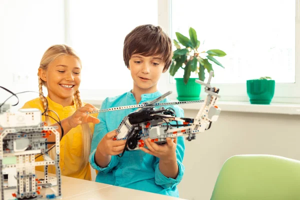 Schoolgirl looking at the helicopter made by her classmate. — Stock Photo, Image