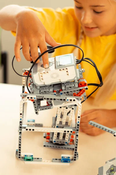 Entusiastiska Schoolgirl slår på en robot hon gjorde. — Stockfoto