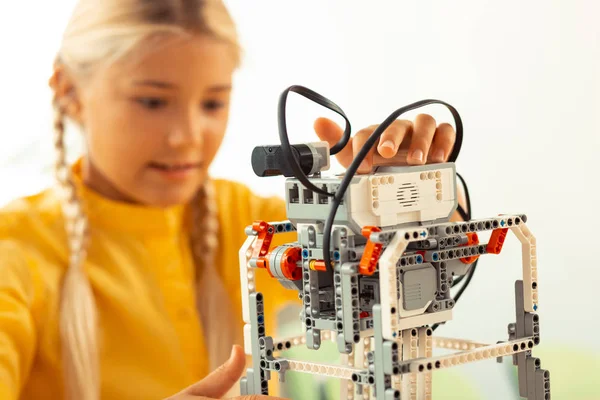 Colegiala trabajando con un modelo de robot en la lección . — Foto de Stock