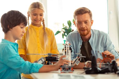 Öğrencisinin çalışmalarına bakan öğretmen.