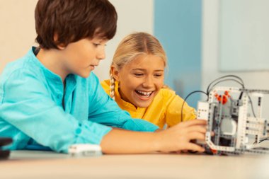 Okul çocukları bir robotla oynarken mutlu.
