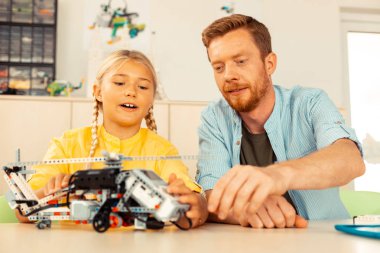 Kız öğrenci öğretmeni ile bir helikopter modeli dönüm.