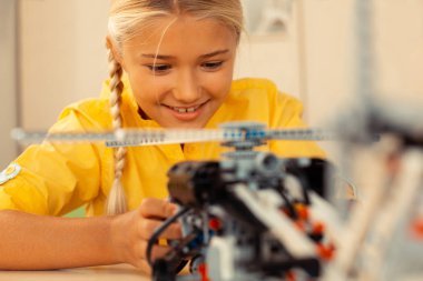 Neşeli kız öğrenci bir helikopter modeli dönüm.