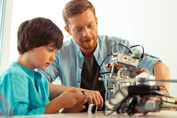 Lärare som stöttar en elev som slår på en robot. — Stockfoto