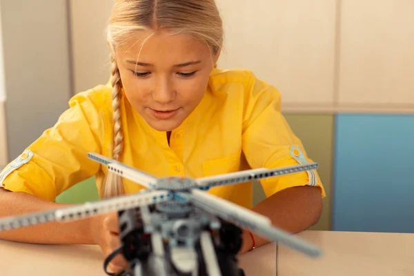 Skolflicka börjar lansera en helikopter modell. — Stockfoto