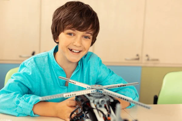 Ragazzo sorridente finendo il suo lavoro sul modello di elicottero . — Foto Stock