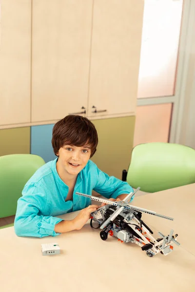 Felice studente mostrando il suo nuovo modello di elicottero . — Foto Stock