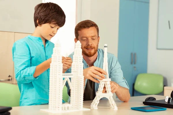 Tanuló segíti a tanári épületet Eiffel-torony miniatűr. — Stock Fotó
