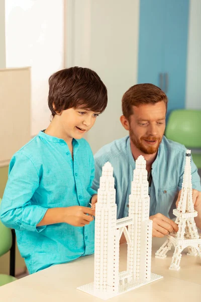 Happy schoolboy making miniatures of famous buildings. — Stock Photo, Image