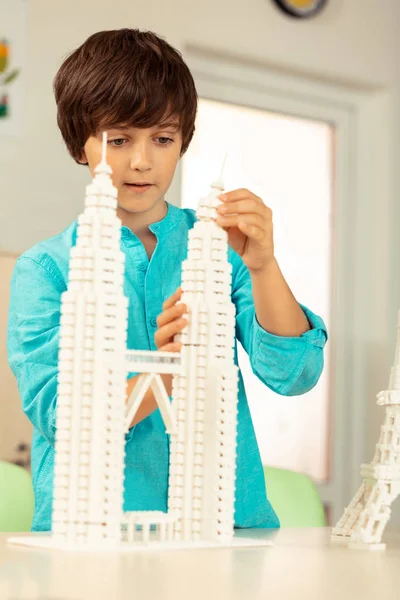 Menino concentrado terminando sua miniatura da ponte de Londres . — Fotografia de Stock