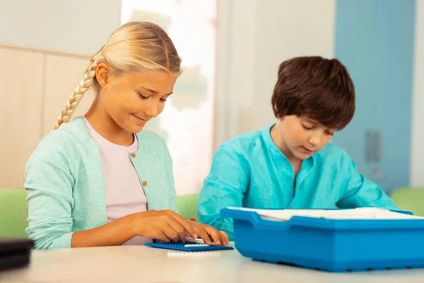 Fille construire une maison pendant sa leçon d'école . — Photo