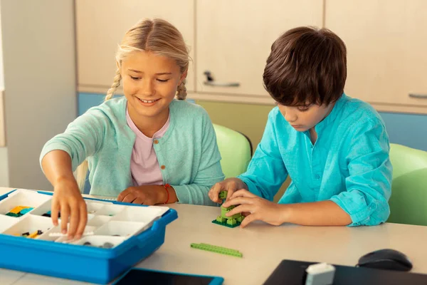 Klasgenoten die figuren opbouwen tijdens hun schoolles. — Stockfoto