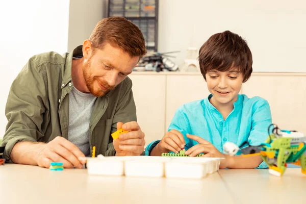 Science teacher building a house with a pupil. — Stock Photo, Image