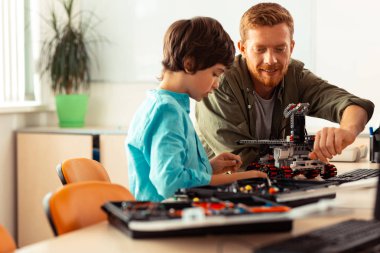 Öğretmen robotunu inşa bir okul çocuğu yardım.