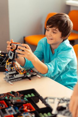 Yaptığı robotla oynayan neşeli çocuk.