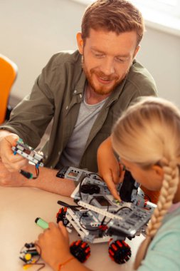 Kız ve öğretmeni robot arabayı açıyorlar..