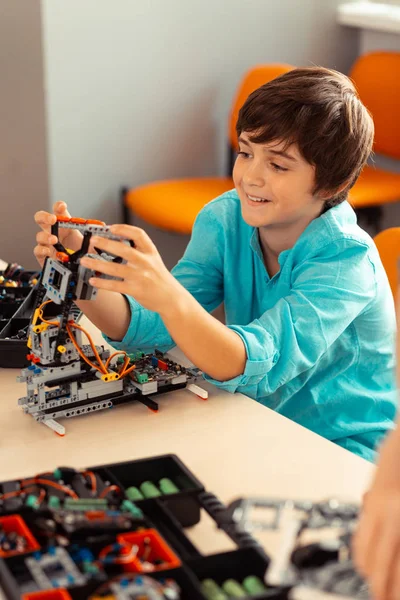 Rapaz alegre brincando com o robô que ele construiu . — Fotografia de Stock