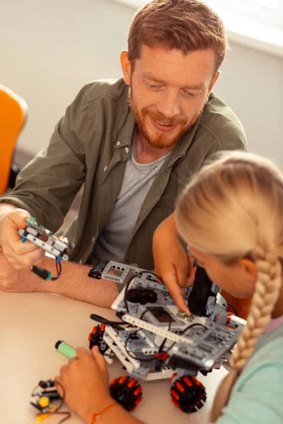 Girl and her teacher turning on the robotic car. — Stock Photo, Image