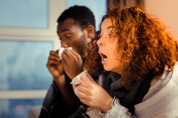 Casal internacional doente tratando seus sintomas de gripe — Fotografia de Stock