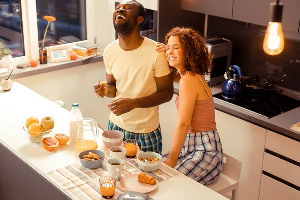 Joyful casal internacional se divertindo durante o café da manhã — Fotografia de Stock