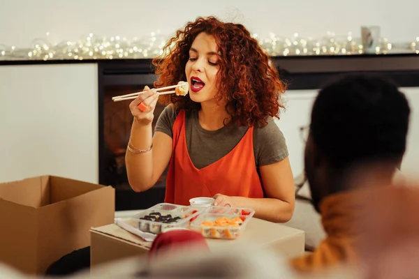 Mulher nova com fome comendo rolos saborosos em casa — Fotografia de Stock