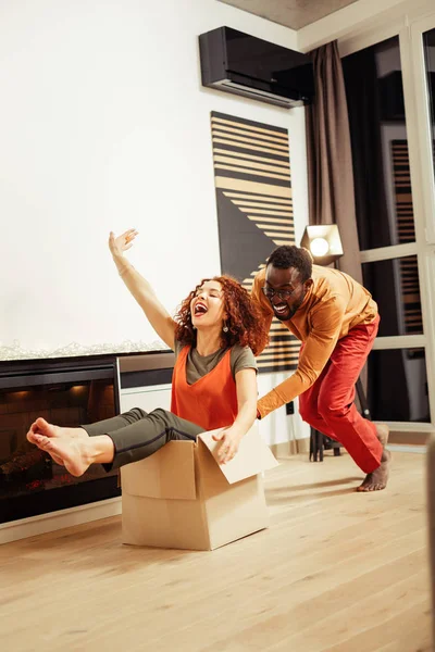 Cheerful young people having fun during removal — Stock Photo, Image