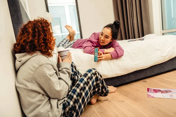 Chica mostrando a un amigo sus mensajes telefónicos — Foto de Stock