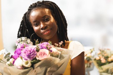 Sevimli koyu tenli çiçekçi kameraya bakıyor